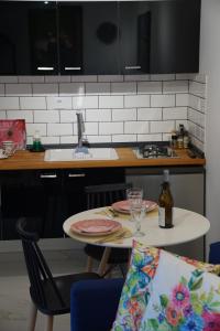 a kitchen with a table with two plates and a bottle of wine at Sougia Glamping in Chania Town