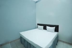 een blauwe kamer met een bed met witte lakens en kussens bij OYO Hotel Shining Star in Bhilai