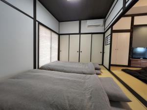 sypialnia z dwoma łóżkami i telewizorem w obiekcie Toyama - House - Vacation STAY 19675v w mieście Toyama