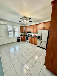 a kitchen with a white tile floor and a ceiling fan at Camino Al Cielo in Guayanilla