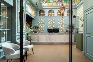 een salon met 2 stoelen en een wachtkamer bij Hotel De Orangerie by CW Hotel Collection - Small Luxury Hotels of the World in Brugge