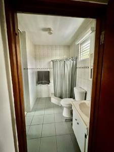 een witte badkamer met een toilet en een wastafel bij Camino Al Cielo in Guayanilla