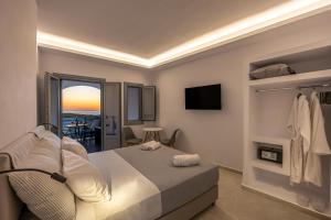 a bedroom with a bed and a view of the ocean at Nastram Suites Oia in Oia