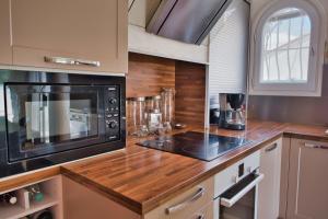 cocina con encimera de madera y microondas en Nice spacious house with garden and swimming pool, en Bompas