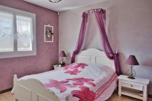 1 dormitorio con cama blanca y cortinas moradas en Nice spacious house with garden and swimming pool, en Bompas