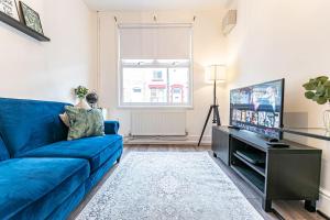 a living room with a blue couch and a tv at Liverpool city centre house, Free parking in Liverpool