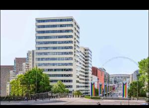 a tall building in a city with flags in front of it at Wembley Park in London