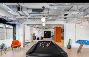 an office with a pool table and an orange chair at Wembley Park in London