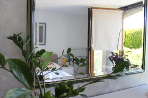 un miroir installé au-dessus d'un canapé avec une plante dans l'établissement Villa Lotus, à Štrigova