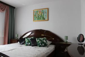 een slaapkamer met een bed met 2 kussens erop bij Villa Lotus in Štrigova