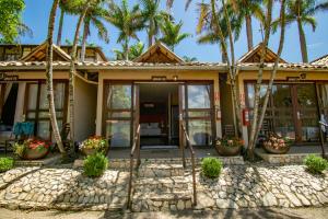 a house with palm trees in front of it at Park Hotel Modelo in Pinhalzinho