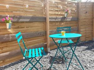 a table and two chairs next to a fence at Studio à la campagne in Saint-Yan