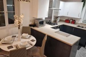 a kitchen with a table with chairs and a microwave at Liam's place in Manchester