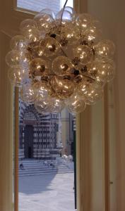 einem großen Kronleuchter aus Glas mit Lichtern in einem Gebäude in der Unterkunft Palazzo Cicala in Genua