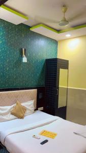 a bedroom with two beds and a green wall at Hotel Avenue Regency in Mumbai