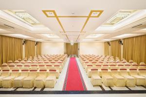 una sala conferenze vuota con tappeto rosso e sedie di Hotel Merrytale a Kurinjippādi