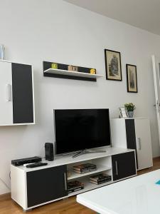- un salon avec une télévision sur un centre de divertissement blanc dans l'établissement Apartment YESA, à Travnik