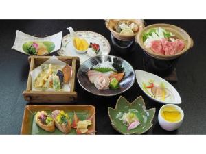 una mesa con platos de comida y tazones de comida en Ikoi no Mura Shimane - Vacation STAY 27447v, en Kyōmendao