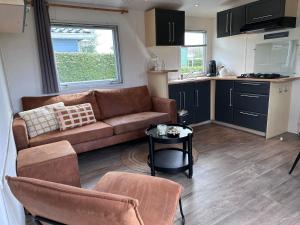 a living room with a couch and a table at Captivating chalet with a microwave, near the Wadden Sea in Tzummarum