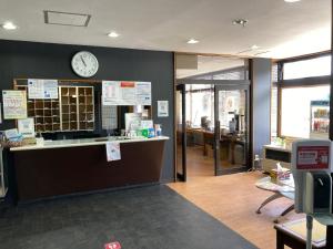 an office with a clock on the wall and a counter at Hotel Tetora Yunokawaonsen - Vacation STAY 30607v in Hakodate