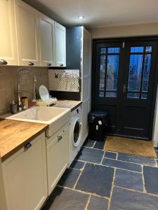 a kitchen with a sink and a washing machine at 1 bed garden flat Islington in London