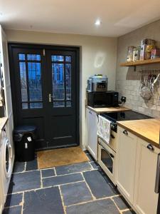 a kitchen with a black door and a counter at 1 bed garden flat Islington in London