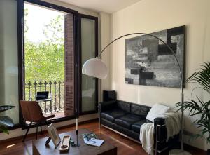 uma sala de estar com um sofá preto e uma janela em Cozy Place Picasso em Barcelona
