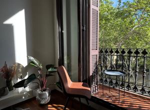 uma varanda com uma cadeira, uma mesa e uma janela em Cozy Place Picasso em Barcelona