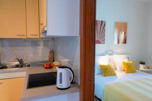 a kitchen with a counter with a toaster and a bed at Apartmani Matiša in Lastovo