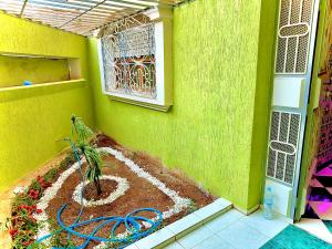 einen Garten in einer grünen Wand mit Gartenschlauch in der Unterkunft Mini villa in Oujda
