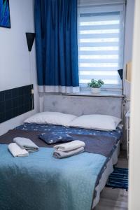 a bed with two towels on it with a window at Apartment L'Orque in Radom