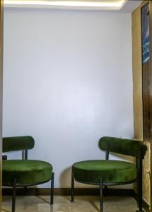 a row of green chairs in a room at Oliver Twist Hotel in Lagos