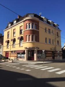 een groot geel gebouw op de hoek van een straat bij Le Royal in Chaumont