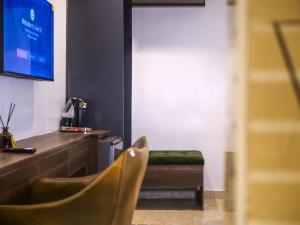 a room with a desk and a chair and a television at Oliver Twist Hotel in Lagos