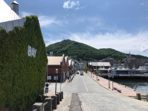 a street next to a body of water with a hill at Hotel Tetora Yunokawaonsen - Vacation STAY 30541v in Hakodate