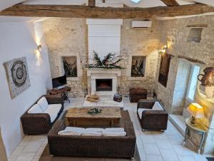 Un gîte en Charente, gîte 4 étoiles في Roullet-Saint-Estèphe: غرفة معيشة مع طاولة ومدفأة