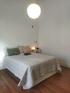 a bedroom with a white bed with a lamp at Casa Buda in La Plata