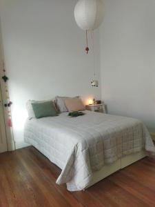 a bedroom with a white bed with a lamp on it at Casa Buda in La Plata
