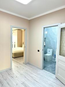 a room with a bathroom with a toilet and a bedroom at Airport- Golden city in Almaty