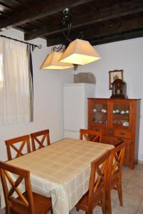 a dining room with a table and chairs and a cabinet at Casa Rural Los Suárez in Agüimes