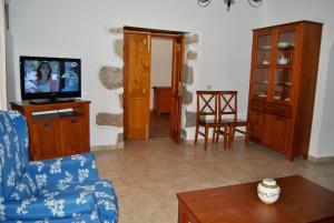 a living room with a blue couch and a tv at Casa Rural Los Suárez in Agüimes