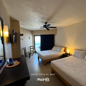 a hotel room with two beds and a tv at Hotel Barra de Navidad in Barra de Navidad