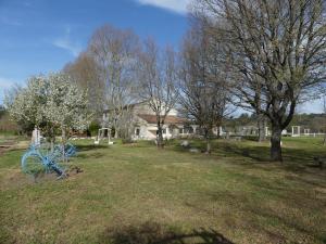 niebieski rower w ogrodzie z drzewami i domem w obiekcie le domaine des sources w mieście Saint-Maximin-la-Sainte-Baume