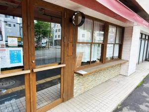 EZO Run Sapporo - Vacation STAY 34518v في سابورو: واجهة متجر بأبواب زجاجية على شارع