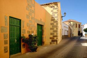 Un callejón con una puerta verde y un edificio. en Casa Rural Los Suárez, en Agüimes