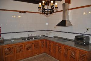 cocina con armarios de madera, fregadero y lámpara de araña en Casa Rural Los Suárez, en Agüimes 52 fotos más
