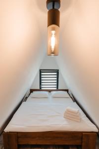 een slaapkamer met een bed onder een plafond met een licht bij CAVO VILLAGE- Cabins Rental Băile 1 Mai in Rontău