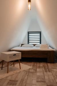a bedroom with a bed and a window at CAVO VILLAGE- Cabins Rental Băile 1 Mai in Rontău
