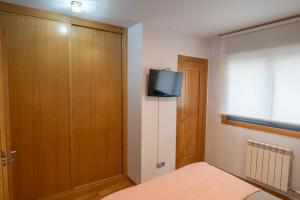 a bedroom with a bed and a tv on the wall at VIGO CENTRO in Vigo