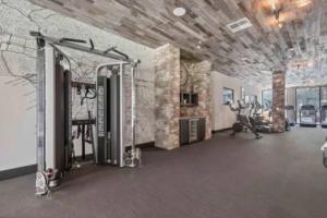 um ginásio com passadeiras e equipamento de exercício numa sala em Chic Luxury Condo near Hollywood em Glendale